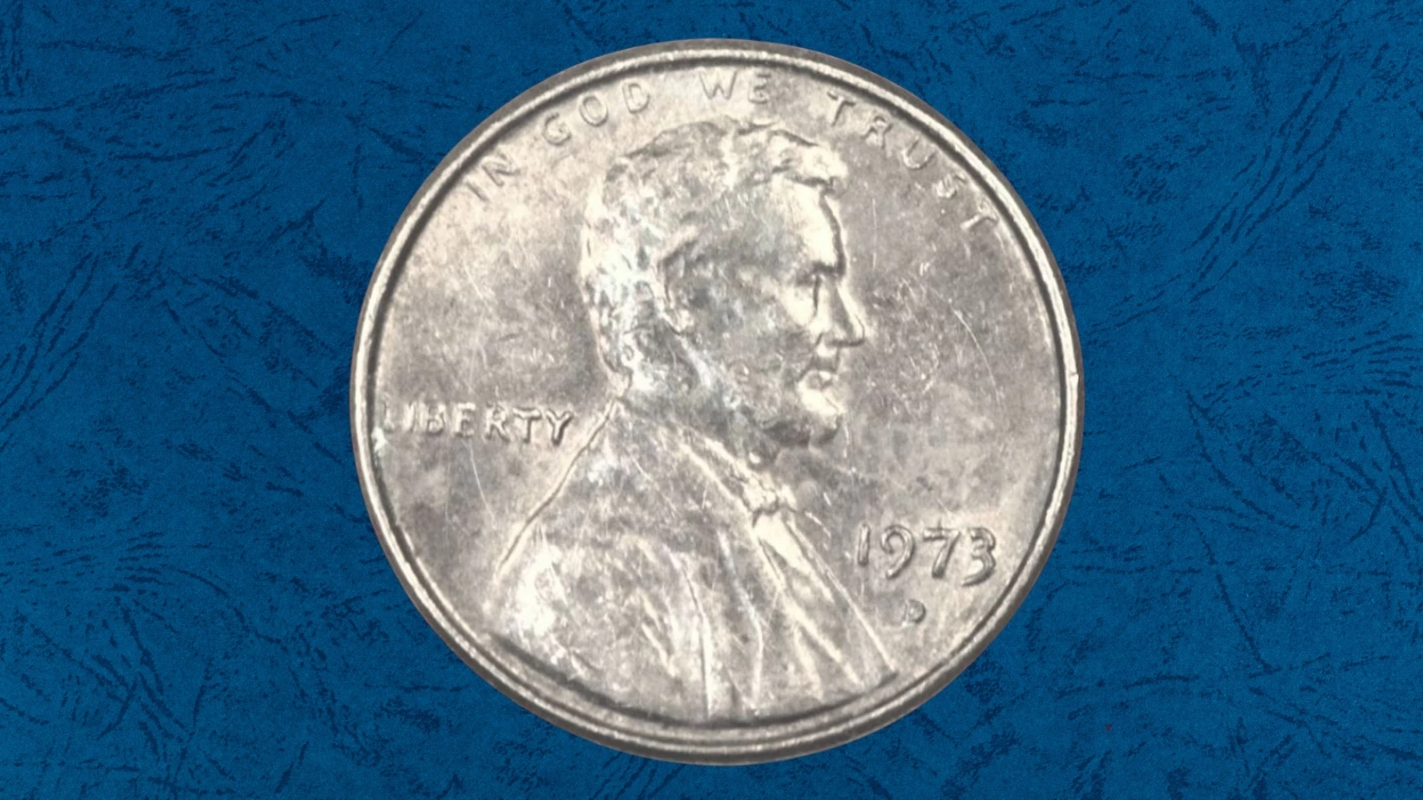 1973 Lincoln penny struck on a dime planchet error showing silver-colored penny design coin smaller than normal, compared to standard size penny